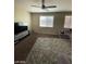 A cozy living room is enhanced by a plush rug, lots of sunlight, and a modern ceiling fan at 2409 W Gilmore Ave, North Las Vegas, NV 89032