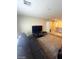 Spacious living room with dark leather sofas, TV, and gray carpet at 2409 W Gilmore Ave, North Las Vegas, NV 89032