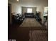 Living room with dark furniture, a neutral rug, and window providing natural light at 2409 W Gilmore Ave, North Las Vegas, NV 89032
