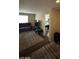 Spacious living area featuring a dark sofa, television, and neutral-colored rug at 2409 W Gilmore Ave, North Las Vegas, NV 89032