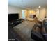 Spacious living room with dark leather sofas, TV, and gray carpet at 2409 W Gilmore Ave, North Las Vegas, NV 89032