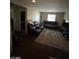 Living room with dark leather seating, area rug and a television at 2409 W Gilmore Ave, North Las Vegas, NV 89032