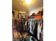 A walk-in closet with clothes hanging on a rod and boxes and stuffed animals on the shelf at 2409 W Gilmore Ave, North Las Vegas, NV 89032
