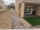 Backyard featuring a covered patio, artificial grass, and decorative rock landscaping at 2704 Willow Wren Dr, North Las Vegas, NV 89084