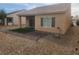 Backyard featuring covered patio with sliding door, artificial turf, and desert landscaping at 2704 Willow Wren Dr, North Las Vegas, NV 89084