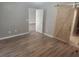 A spacious bedroom with wood-like floors and a barn door entrance to the bathroom at 2704 Willow Wren Dr, North Las Vegas, NV 89084