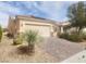 Inviting single-story home with desert landscaping, solar panels, and a brick driveway at 2704 Willow Wren Dr, North Las Vegas, NV 89084
