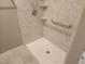 A shower with a rainfall showerhead, convenient grab bars, and corner shelves for toiletries at 2704 Willow Wren Dr, North Las Vegas, NV 89084
