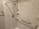 A shower with a rainfall showerhead, convenient grab bars, and corner shelves for toiletries at 2704 Willow Wren Dr, North Las Vegas, NV 89084