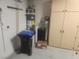 Utility Room featuring a water heater, water softener, and storage cabinets at 2704 Willow Wren Dr, North Las Vegas, NV 89084