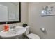 Well-lit half bathroom featuring a pedestal sink and decorated with a stylish framed mirror at 2878 Starling Summit St, Henderson, NV 89044