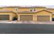 A row of tan townhomes featuring private garages and tiled roofs, offering a cohesive and appealing street view at 2878 Starling Summit St, Henderson, NV 89044