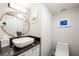 Modern half bathroom with a vessel sink, granite countertops, round mirror and contemporary fixtures at 3111 Bel Air Dr # 10F, Las Vegas, NV 89109
