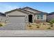 Charming single-story home featuring desert landscaping, a gray exterior, and a spacious two-car garage at 378 Hellebores Ave, North Las Vegas, NV 89084