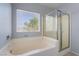 Bright bathroom showcasing a soaking tub with a window and a separate glass-enclosed shower at 5100 Amethyst Creek Ct, Las Vegas, NV 89131