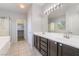 Ensuite bathroom with dual sink vanity, glass-enclosed shower, and walk-in closet at 5100 Amethyst Creek Ct, Las Vegas, NV 89131