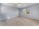 Spacious carpeted primary bedroom featuring a ceiling fan and large window overlooking the yard at 5100 Amethyst Creek Ct, Las Vegas, NV 89131
