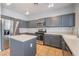 Well-equipped kitchen with stainless steel appliances, grey cabinets, and a kitchen island at 5100 Amethyst Creek Ct, Las Vegas, NV 89131