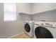 Functional laundry area featuring modern, front-loading washing machine and dryer and natural light at 5100 Amethyst Creek Ct, Las Vegas, NV 89131
