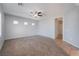 Spacious carpeted living room with a ceiling fan and multiple windows providing ample natural light at 5100 Amethyst Creek Ct, Las Vegas, NV 89131