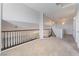 Upstairs loft with carpet and dark railing overlooking staircase, featuring decorative lighting at 5100 Amethyst Creek Ct, Las Vegas, NV 89131