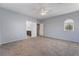 Large primary bedroom with view to ensuite bathroom and an arched window with plantation shutters at 5100 Amethyst Creek Ct, Las Vegas, NV 89131