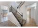 Carpeted staircase with dark wood and wrought iron railing, connecting to the upper level of the home at 5100 Amethyst Creek Ct, Las Vegas, NV 89131