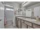 Neutral bathroom with dual vanity, decorative accents, and a shower-tub combo at 5232 Mountain Garland Ln, North Las Vegas, NV 89081