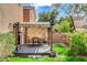An inviting covered patio features chairs and a dining table, and is surrounded by a grassy lawn at 5513 Nickel Ridge Way, Las Vegas, NV 89122