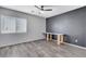 Bedroom with wood-look floors, a desk, ceiling fan and a dark accent wall at 5513 Nickel Ridge Way, Las Vegas, NV 89122