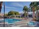 Community pool with lounge chairs, palm trees, and shaded cabana area at 5513 Nickel Ridge Way, Las Vegas, NV 89122