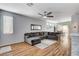 Open-concept living area with wood flooring, a large sectional sofa, and ample natural light at 5513 Nickel Ridge Way, Las Vegas, NV 89122