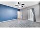 Large bedroom with plush carpeting, ensuite bathroom access and a colorful accent wall at 5513 Nickel Ridge Way, Las Vegas, NV 89122