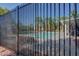 Community pool with palm trees and lounge chairs, enclosed by a black metal fence at 5513 Nickel Ridge Way, Las Vegas, NV 89122