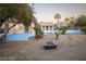 Backyard oasis with a vibrant blue pool and jacuzzi, plus a lounging area and desert landscaping at 5527 Breecher Ave, Las Vegas, NV 89131