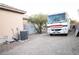 Large RV parked in the gravel driveway with a storage shed and air conditioning unit on the side of the house at 5527 Breecher Ave, Las Vegas, NV 89131
