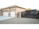 Home exterior with three-car garage, gravel landscaping, and RV parking behind an iron gate at 5527 Breecher Ave, Las Vegas, NV 89131