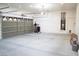 Empty three-car garage with overhead storage, utility hookups, and paneled doors at 5527 Breecher Ave, Las Vegas, NV 89131