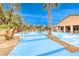 Backyard has an in-ground pool and spa, desert landscaping, trees and shrubs and a multi-colored patio set at 5527 Breecher Ave, Las Vegas, NV 89131