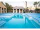 Bright blue backyard pool with a jacuzzi, pool house, and lounge area with palm trees at 5527 Breecher Ave, Las Vegas, NV 89131