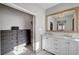 Bright bathroom with double vanity, chandelier, and walk-in closet at 5712 Almocita Ct, Las Vegas, NV 89141