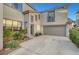 Exterior view of home showcasing a two-car garage and well-maintained landscaping at 5712 Almocita Ct, Las Vegas, NV 89141