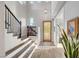 Two story foyer featuring a staircase and wooden front door, creating a welcoming entrance at 5712 Almocita Ct, Las Vegas, NV 89141