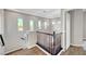 Bright hallway with wood floors, decorative banister, and multiple windows offering natural light and views at 5712 Almocita Ct, Las Vegas, NV 89141