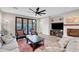 Bright living room with fireplace, wood floors, ceiling fan, and bi-fold doors to outdoor space at 5712 Almocita Ct, Las Vegas, NV 89141