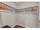 A walk-in closet with minimalist wood fixtures for hanging clothes at 5712 Almocita Ct, Las Vegas, NV 89141
