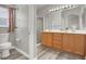 Bright bathroom features double vanity, wood cabinets, and a glass-enclosed shower at 5954 Rose Sage St, North Las Vegas, NV 89031