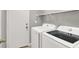 Functional laundry room with modern, white, front-loading washer and dryer appliances at 5954 Rose Sage St, North Las Vegas, NV 89031