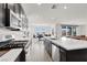 Open kitchen layout with stainless steel appliances, a large island, and a view into the living area at 6261 Lamont Hills Ave, Las Vegas, NV 89139
