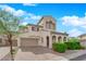 Beautiful home showcasing arched entryway, paved driveway, and lush landscaping at 6647 Rego Park Ct, Las Vegas, NV 89166